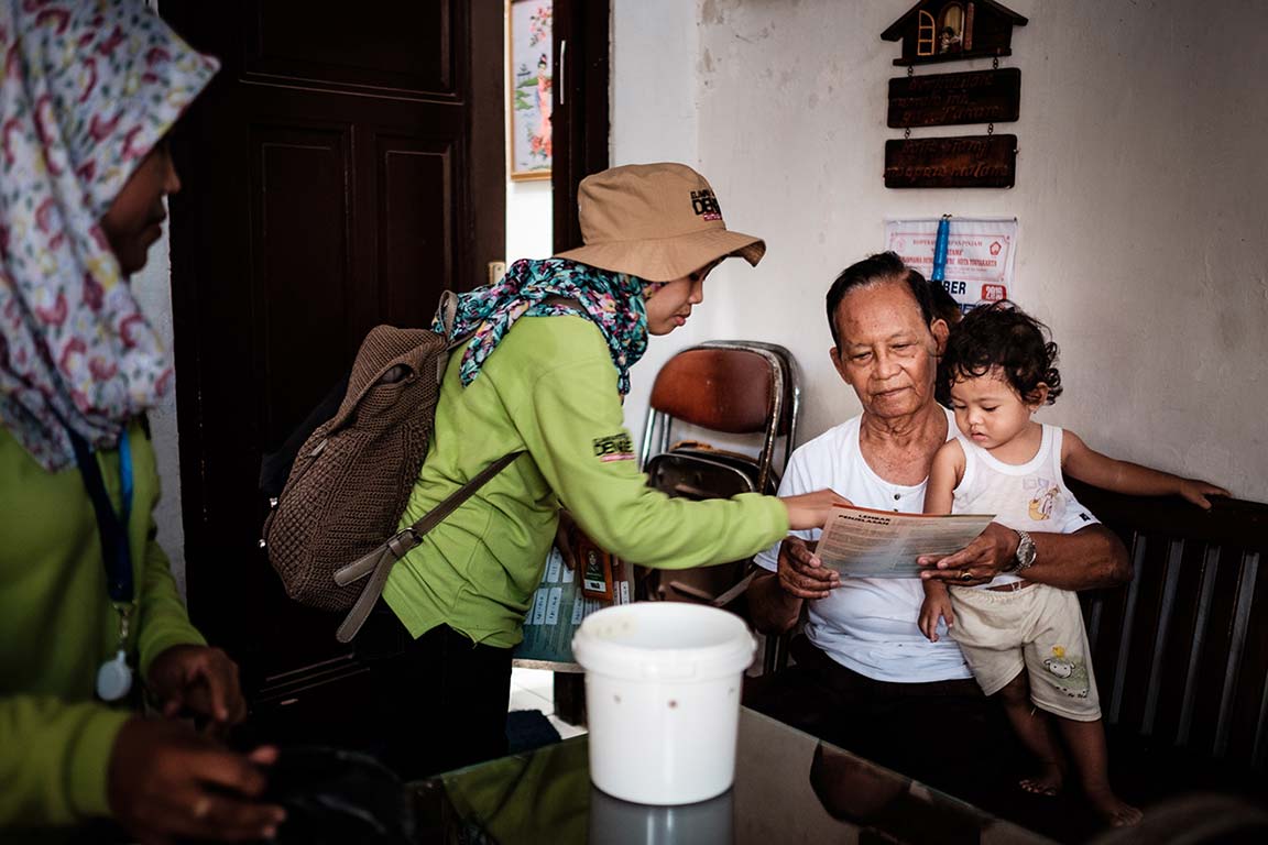 Projektmitarbeiter erklären den Bewohnern des Viertels, wie die Dengue-Überträger bekämpft werden.