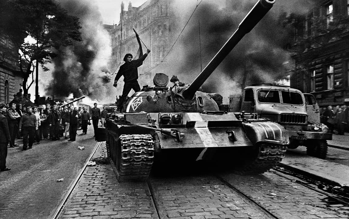 Straßenkrieg, Prag, 1968: Josef Koudelka fotografiert den Prager Frühling. Mit zwei Exakta-Kameras über den Schultern, in den Taschen hunderte Rollen Film, die er zuvor aus Kinorollen geschnitten hatte. Die Bilder gingen später um die Welt. Erst im Schutz der Anonymität. Dann mit vollem Namen: „Josef Koudelka, Magnum“.